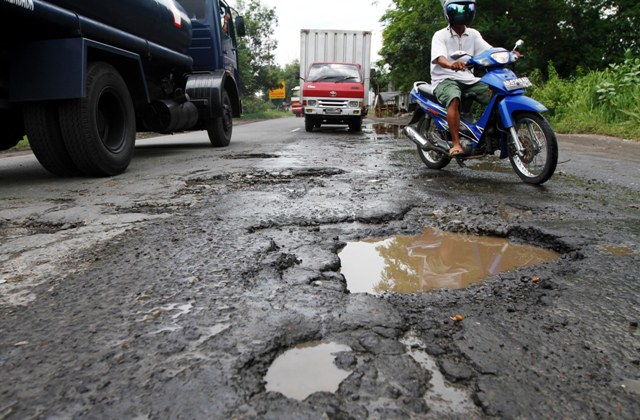 JIBI/SOLOPOS/Burhan Aris Nugraha JALAN RUSAK--Pengendara mobil dan motor melintasi jalan berlubang di Jalan Adisumarmo, Colomadu, Karanganyar, Kamis (8/3). Jalan yang menghubungkan Colomadu dan Kartasura, Sukoharjo tersebut kondisinya rusak dan banyak lubang yang membahayakan pengguna jalan.
