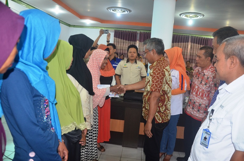 Bupati Martin rantan menyerahkan Buku Tabungan dana bantuan PKH kepada warga Delta pawan