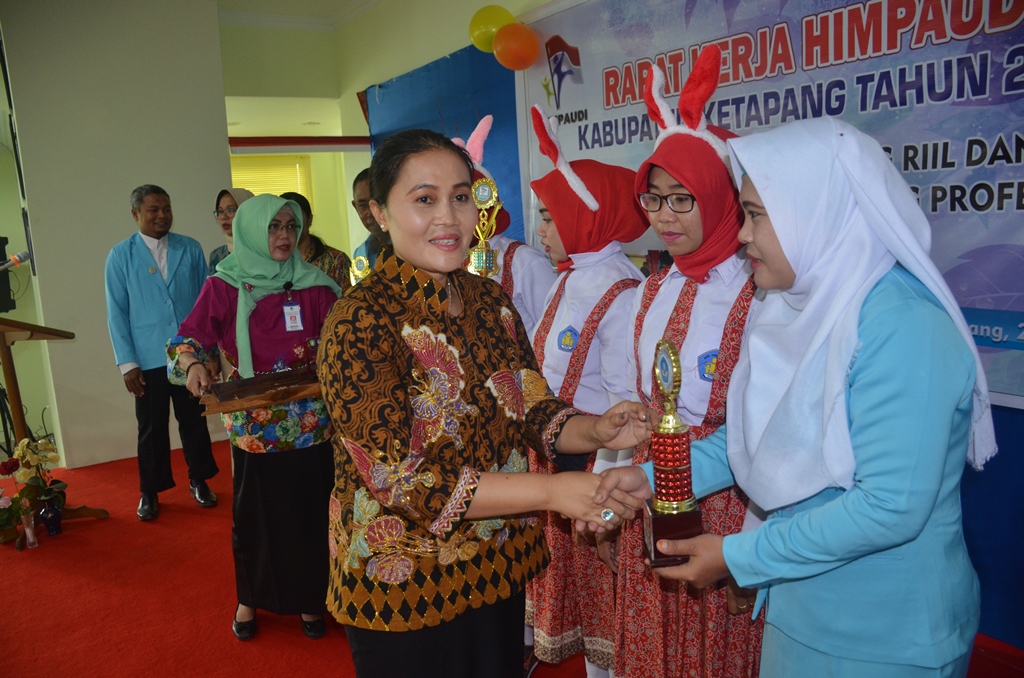 Bunda Paud Ny Elysabet Betty Martin Rantan menyerahkan hadiah kepada tenaga pendidik PAUD tahun 2017 usai membuka Rakre HIMPAUDI di aula Bank Kalbar Ketapang