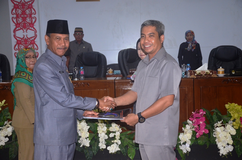 Mewakili Bupati Sekda H.M. Farhan SE.M.Si menyerahkan Nota Kesepakatan kepada Wakil Ketua DPRD Junaidi SP usai sidang paripurna di gedung DPRD Ketapang.,jpg